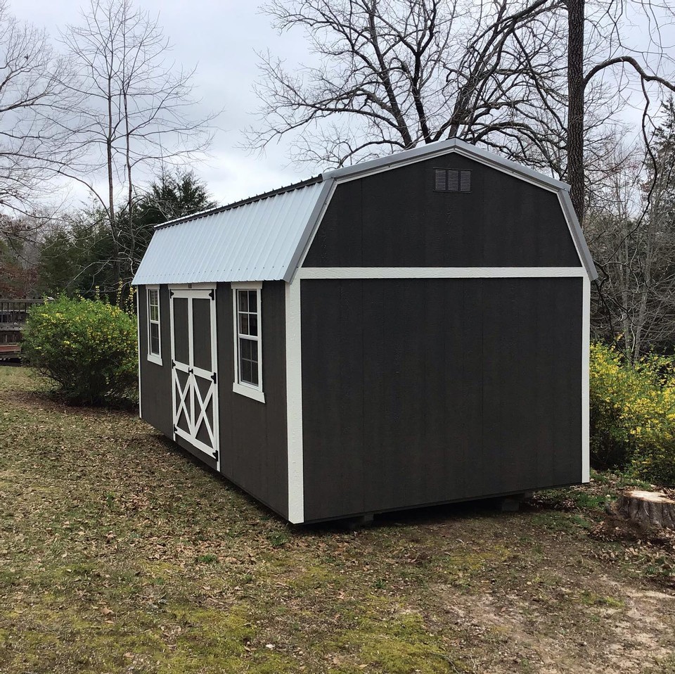 A black shed with white trim by Westwood Sheds.