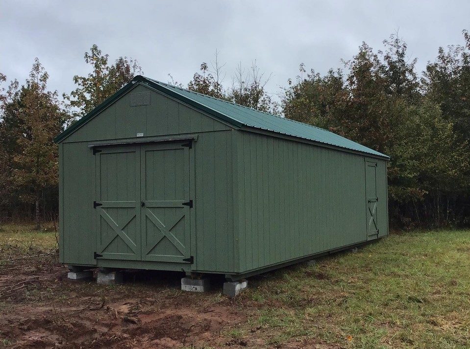 A green shed with green trim by Westwood Sheds.